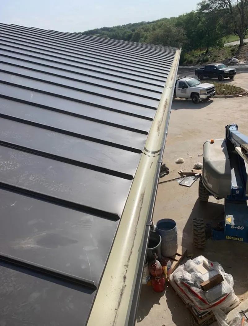 Standing seam panel and gutter detail on a metal roofing jobsite in Caledonia